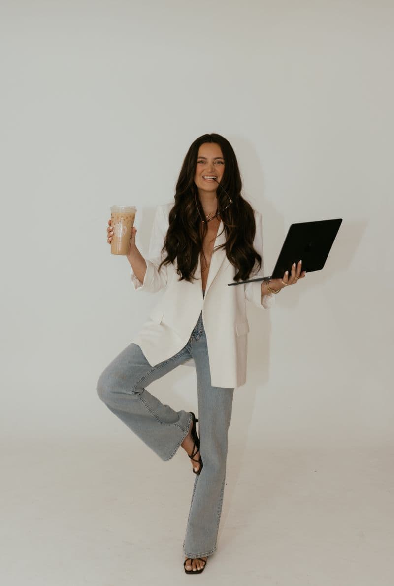 Sara Uy holding an iced coffee and a laptop